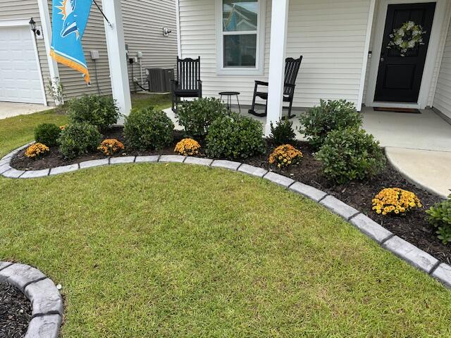 Seasonal mum and boxwood planting bed along a front porch