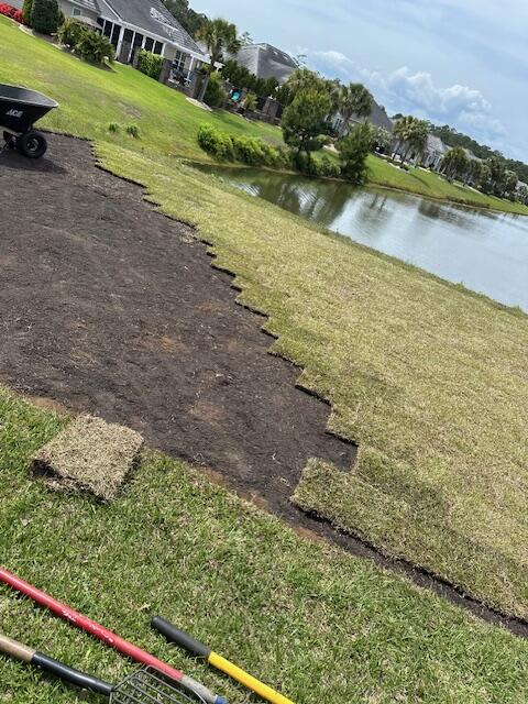 Fresh strips of sod being laid during a sod installation on a lakeside Grand Strand property